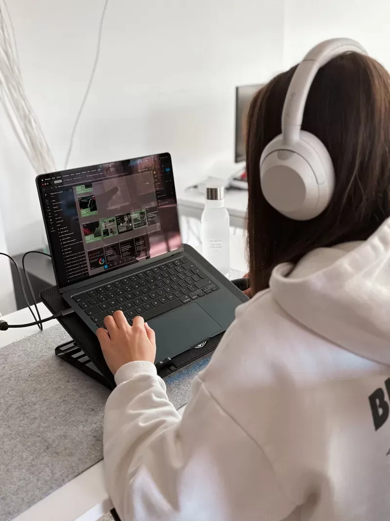 A BigConvert designer working on ROAS and POAS creatives on a laptop